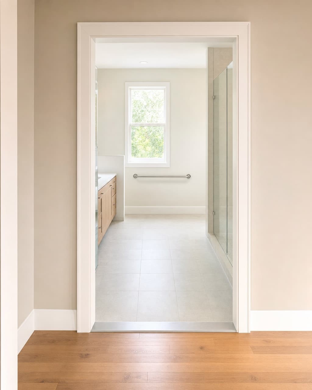 A widened bathroom doorway seen from the hallway with a low bevelled threshold strip